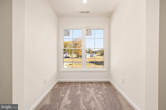 empty room with visible vents, baseboards, and carpet