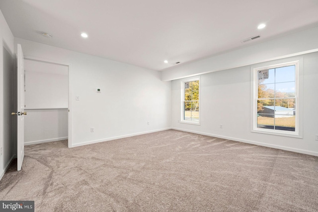 carpeted spare room featuring visible vents, recessed lighting, and baseboards