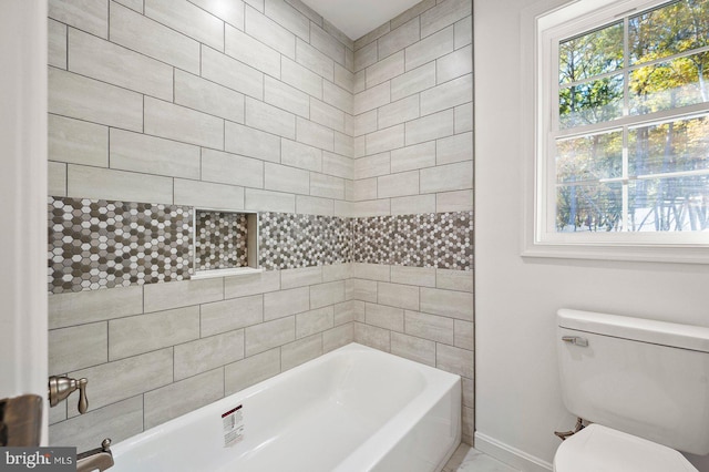 full bathroom with baseboards, toilet, and a tub to relax in