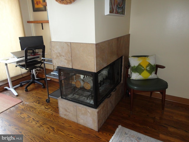 interior space featuring a fireplace, wood finished floors, and baseboards