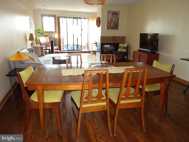 dining room featuring a multi sided fireplace and hardwood / wood-style flooring