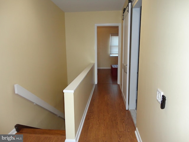 hall featuring a barn door and hardwood / wood-style floors