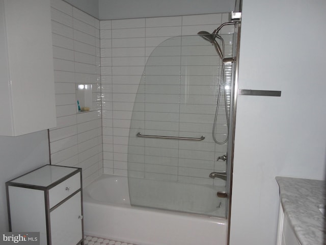 bathroom with tiled shower / bath combo and vanity