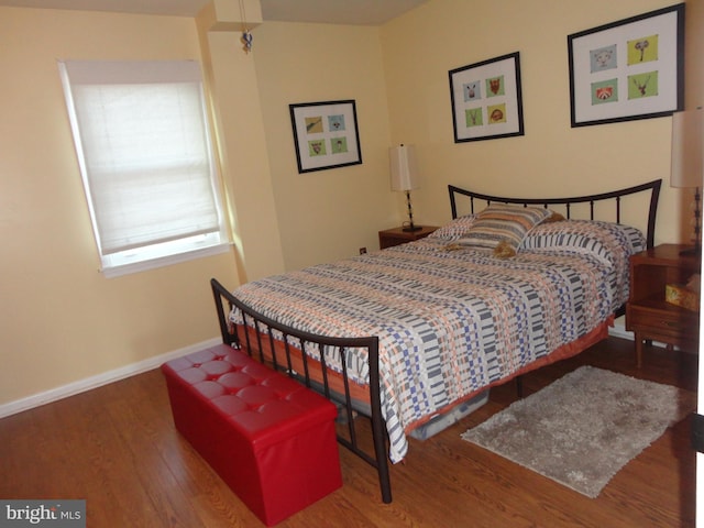 bedroom with dark hardwood / wood-style flooring and a skylight