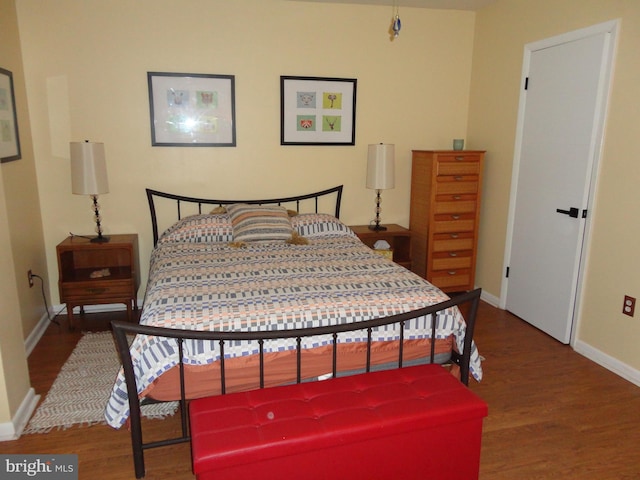 bedroom with dark hardwood / wood-style floors