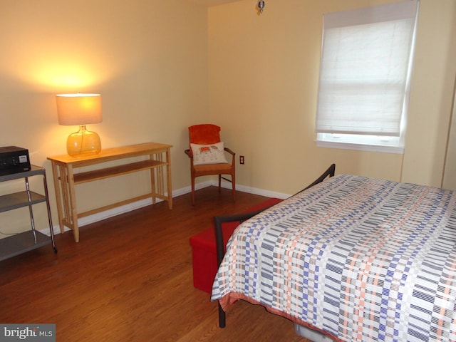 bedroom with dark hardwood / wood-style floors