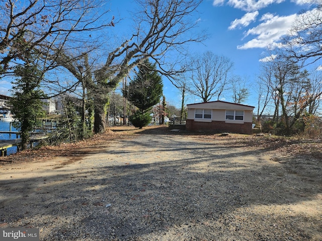 view of side of home featuring brick siding and driveway