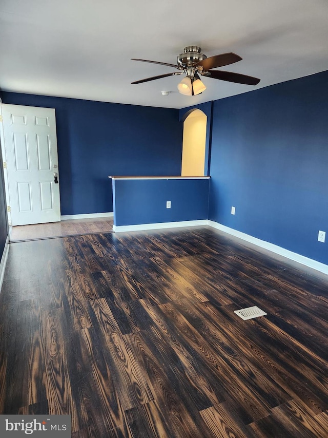 spare room with ceiling fan, baseboards, and wood finished floors