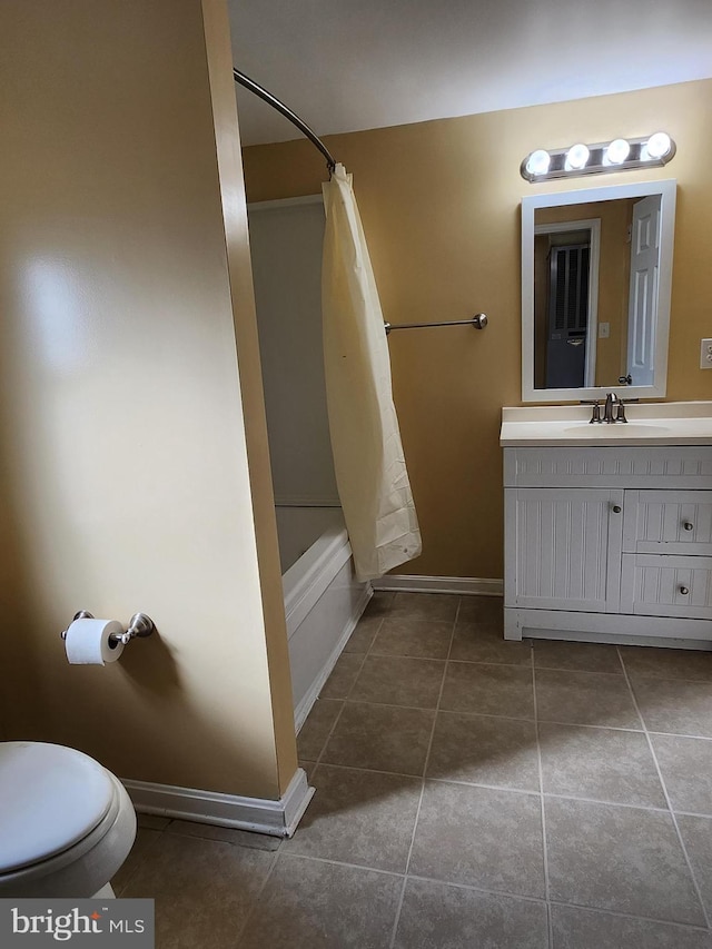 bathroom featuring tile patterned flooring, baseboards, shower / bath combo with shower curtain, toilet, and vanity