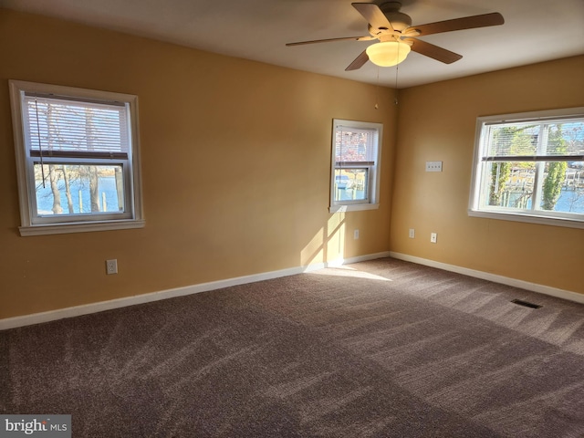 empty room with visible vents, baseboards, ceiling fan, and carpet flooring