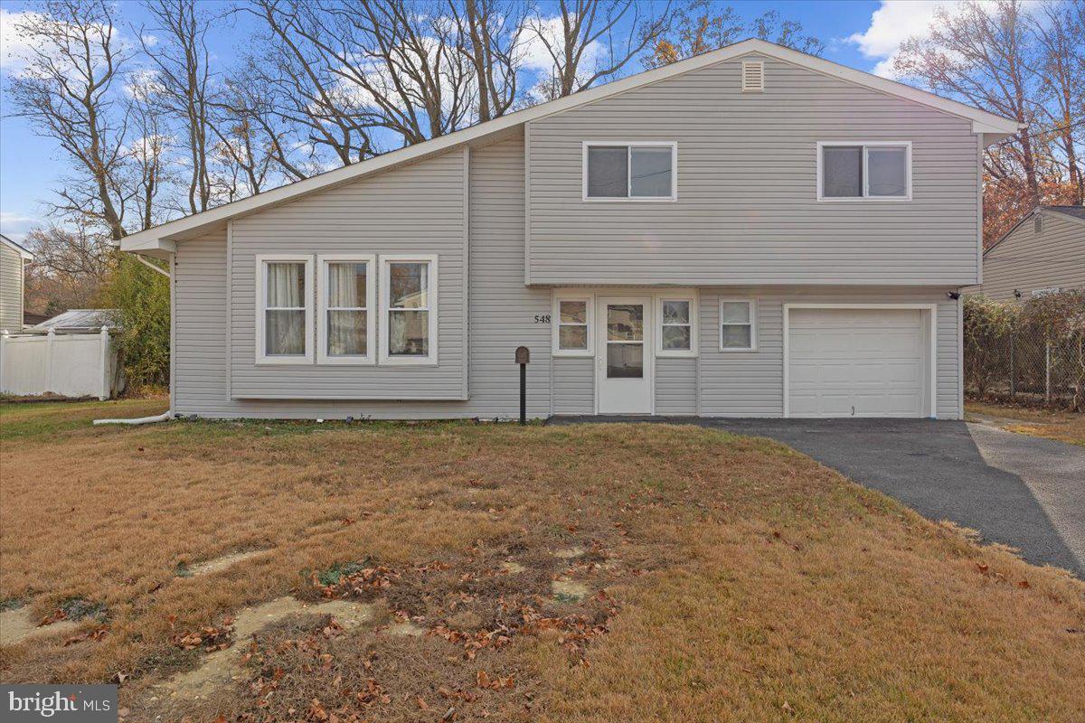 split level home with a garage and a front yard