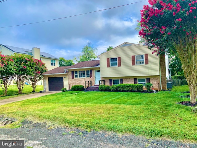 tri-level home with a front yard and a garage