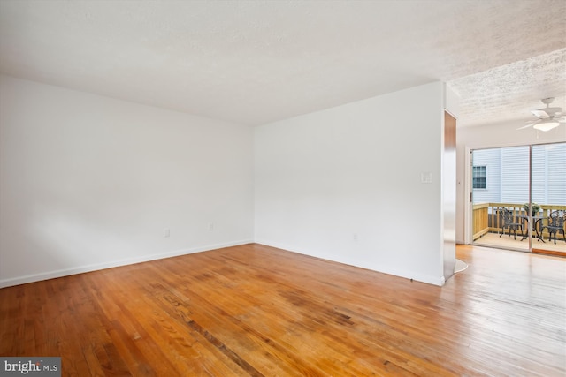 unfurnished room featuring light wood-type flooring, ceiling fan, and a textured ceiling