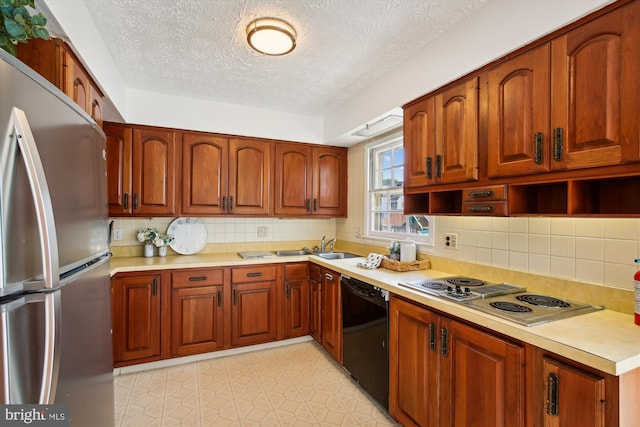 kitchen featuring a textured ceiling, sink, light tile patterned flooring, appliances with stainless steel finishes, and backsplash