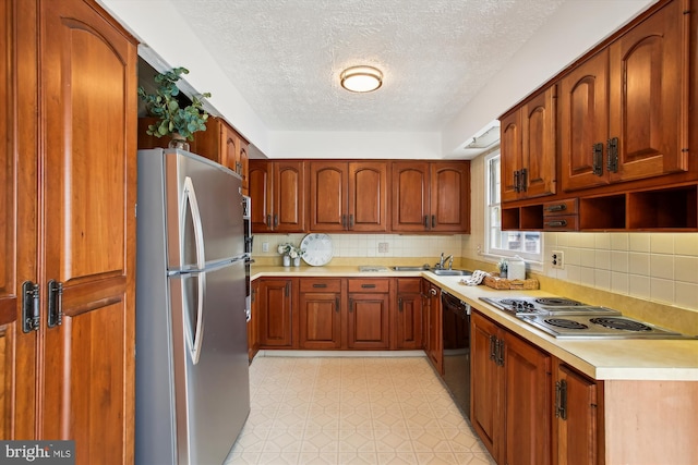 kitchen with decorative backsplash, appliances with stainless steel finishes, and a textured ceiling