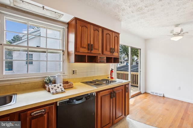 kitchen featuring a healthy amount of sunlight, black dishwasher, stainless steel gas stovetop, and tasteful backsplash