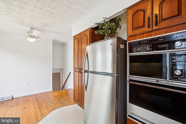 kitchen with ceiling fan, a textured ceiling, light wood-type flooring, and black appliances