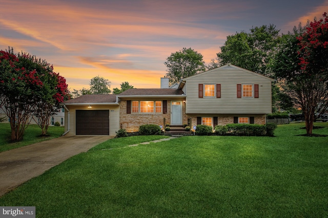 tri-level home featuring a garage and a lawn