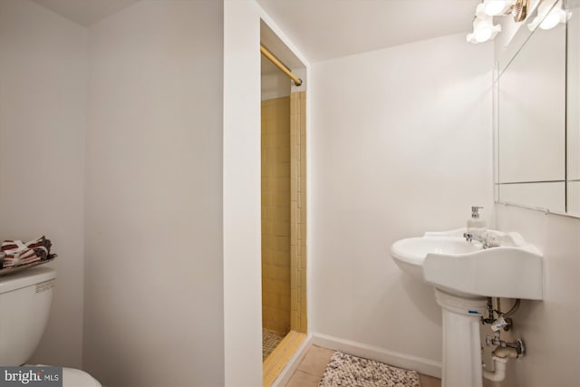 bathroom featuring tile patterned floors, toilet, and tiled shower