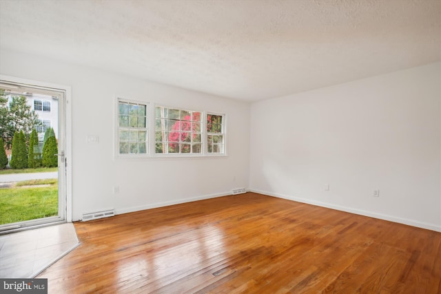 spare room featuring wood-type flooring and a textured ceiling