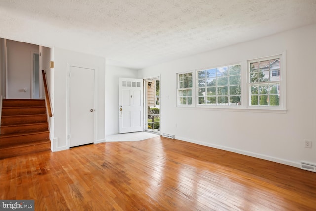 spare room with hardwood / wood-style floors and a textured ceiling