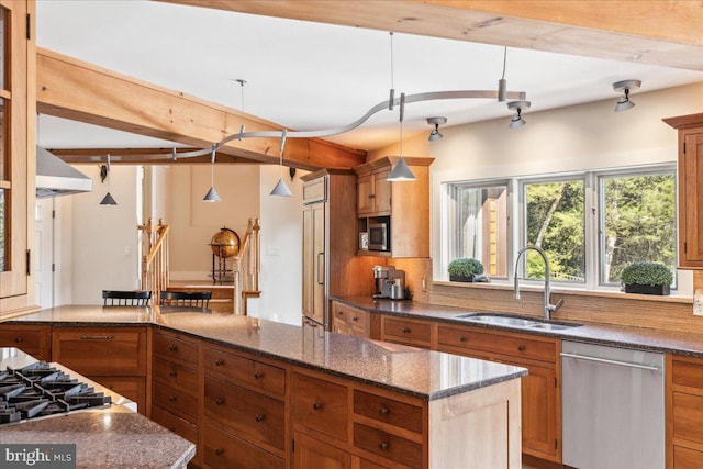 kitchen featuring backsplash, decorative light fixtures, stainless steel appliances, a center island, and sink