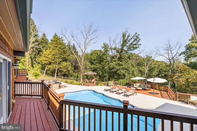 view of swimming pool with a wooden deck and a patio area