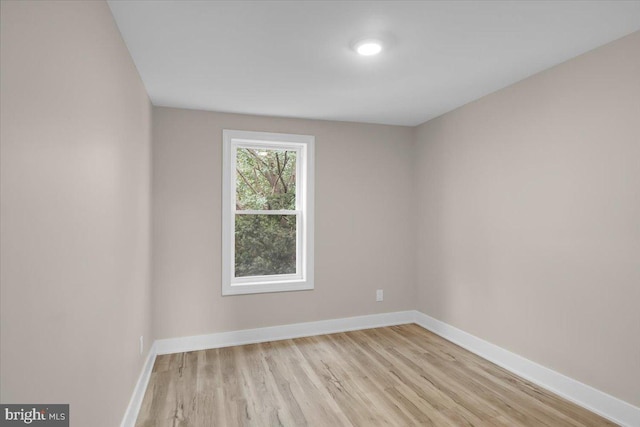 empty room featuring baseboards and light wood-style flooring