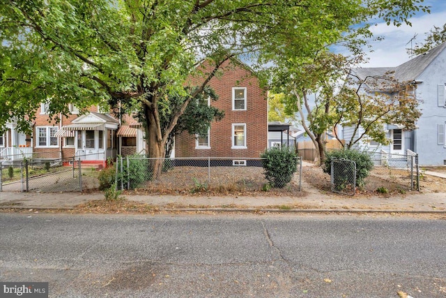 view of front of house featuring a gate, brick siding, and a fenced front yard