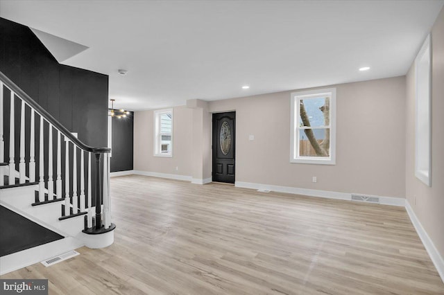 interior space featuring stairs, baseboards, visible vents, and light wood-type flooring