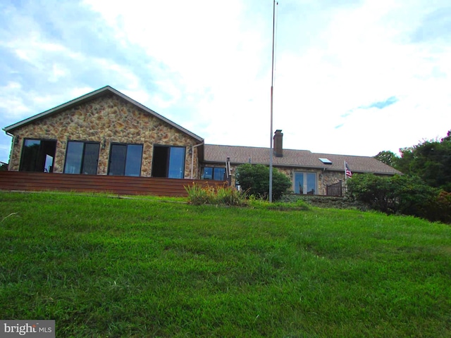 view of front facade featuring stone siding and a front yard