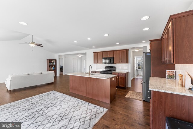 kitchen with black appliances, light stone counters, ceiling fan, dark wood-type flooring, and vaulted ceiling