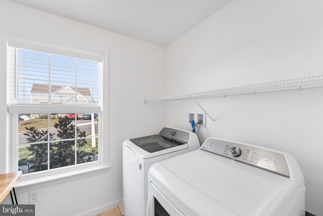 clothes washing area with a wealth of natural light and washing machine and dryer