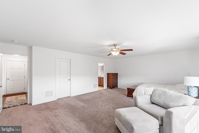 living area with light carpet and ceiling fan