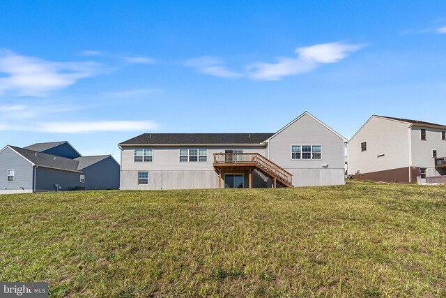 back of property featuring a lawn and a deck