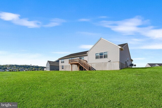 rear view of property with a lawn and a deck