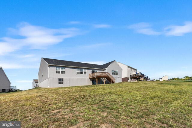 back of house with a wooden deck and a yard