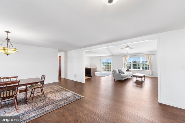 living room featuring ceiling fan and dark hardwood / wood-style floors