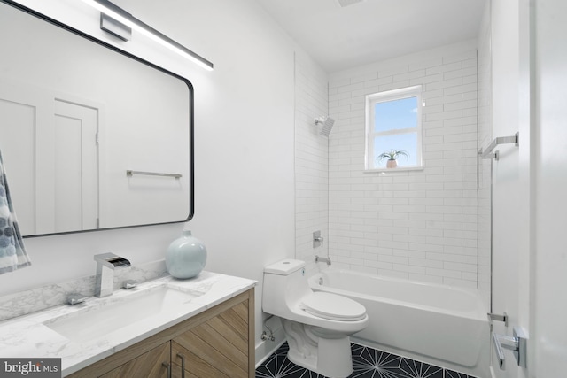 full bathroom featuring tile patterned flooring, tiled shower / bath, toilet, and vanity