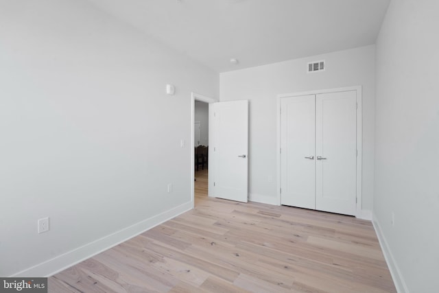 unfurnished bedroom featuring a closet and light hardwood / wood-style flooring