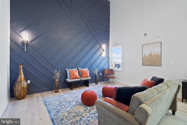 living room with light wood-type flooring and a high ceiling