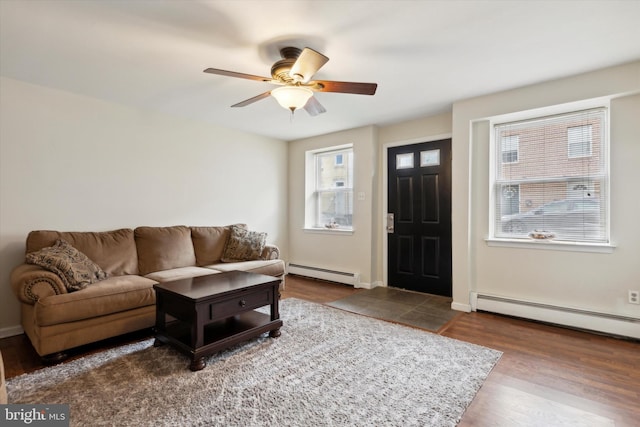 living room with ceiling fan, baseboard heating, and wood-type flooring