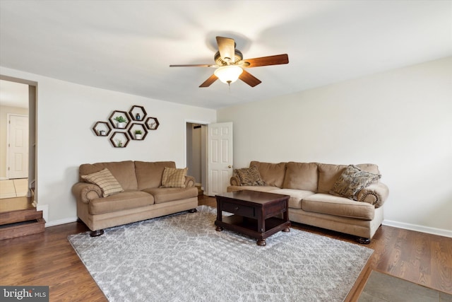 living room featuring ceiling fan and dark hardwood / wood-style floors