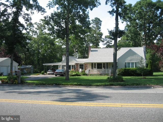 single story home featuring a carport, a front yard, and covered porch