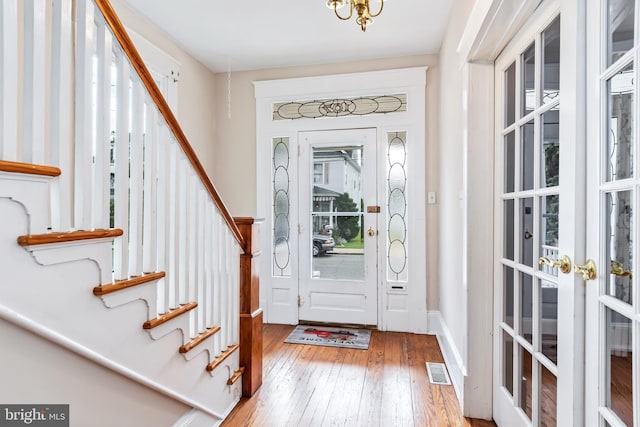 entryway featuring stairs, hardwood / wood-style flooring, and visible vents