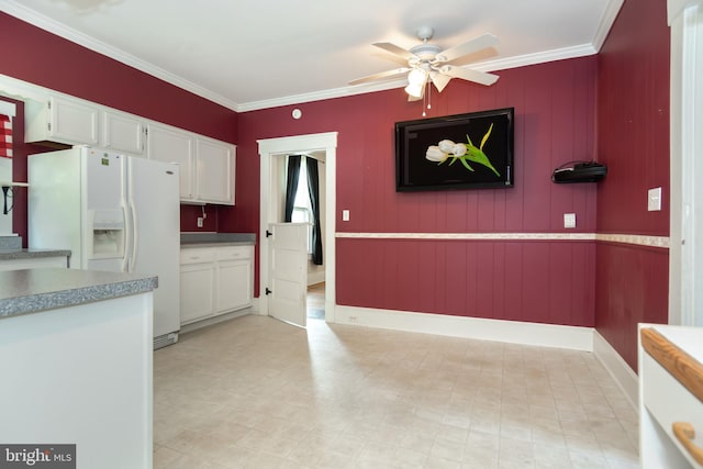 kitchen with light countertops, ornamental molding, white refrigerator with ice dispenser, white cabinetry, and a ceiling fan