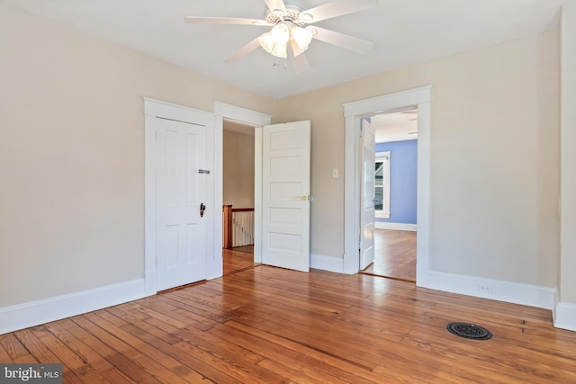 empty room with baseboards, ceiling fan, and hardwood / wood-style flooring