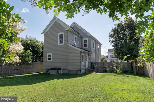 rear view of property with central AC unit, a fenced backyard, and entry steps