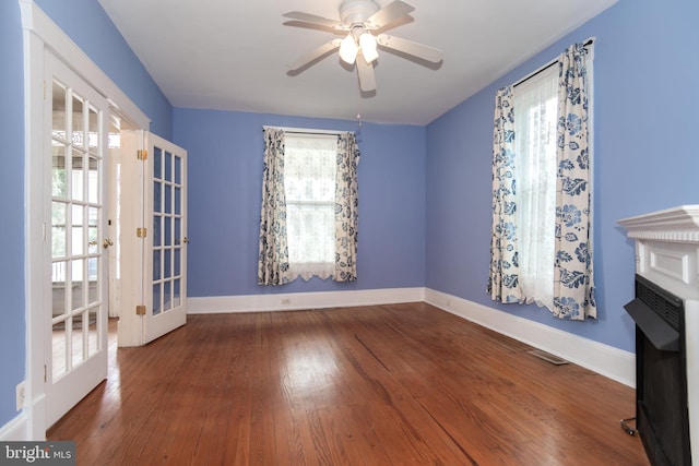 spare room featuring wood finished floors, baseboards, french doors, and ceiling fan