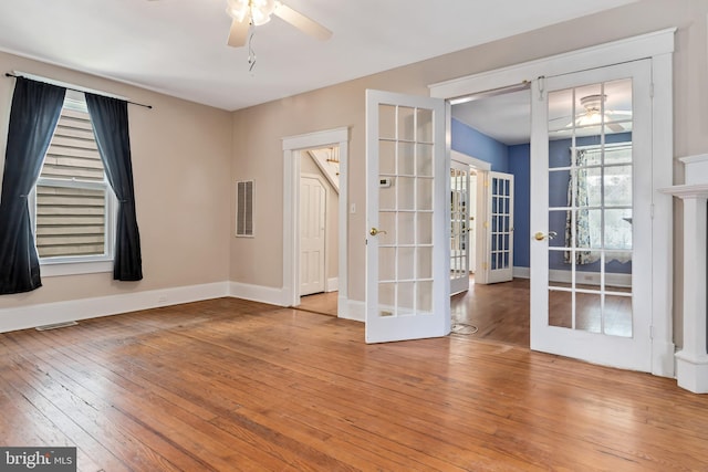 unfurnished room featuring visible vents, french doors, baseboards, and hardwood / wood-style flooring